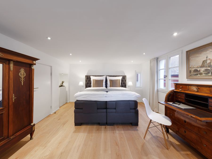 Schlafzimmer mit Boxspringbett und antiken Möbeln